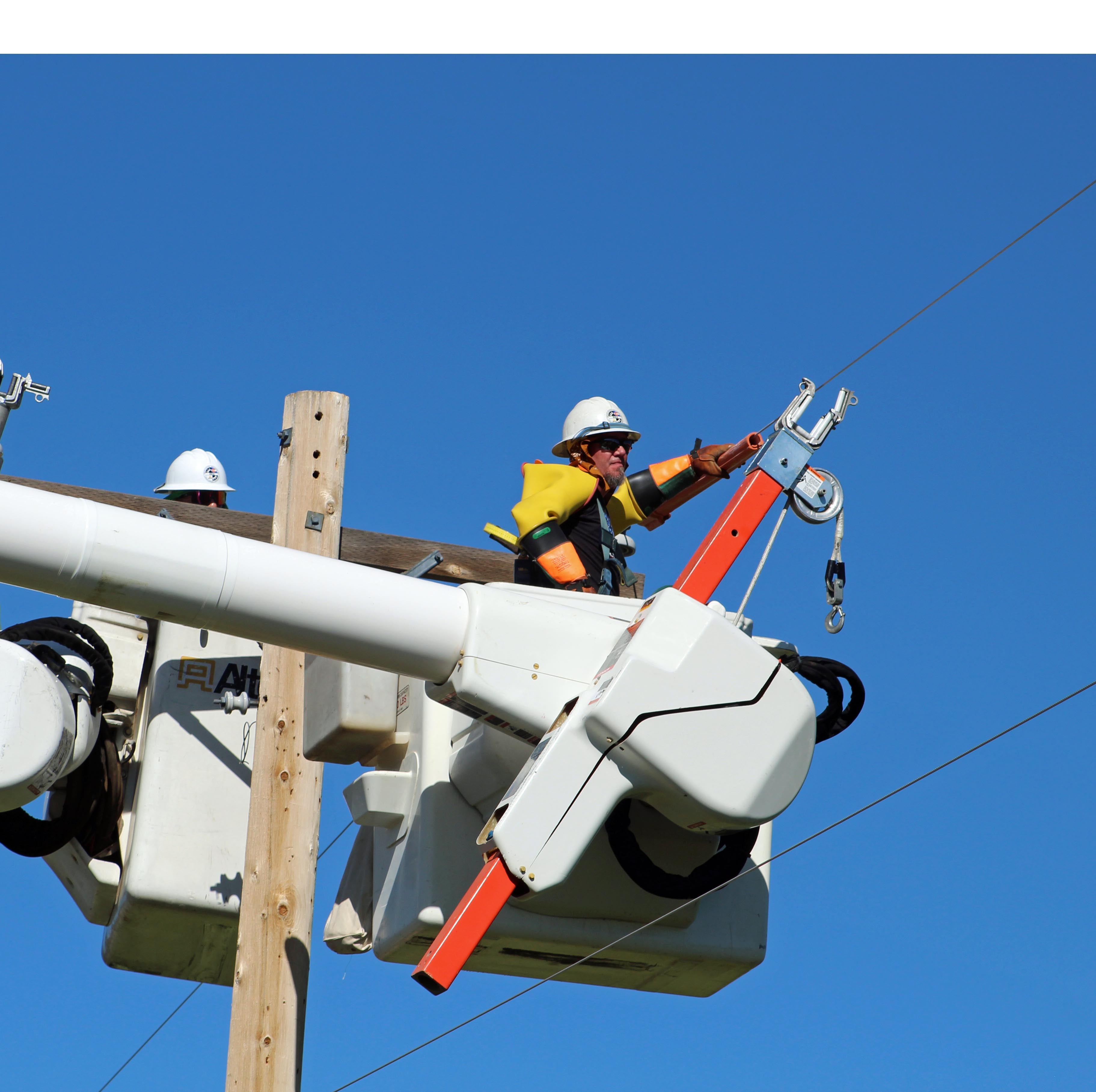EEA lineman in bucket performing hotline work wearing full protective gear